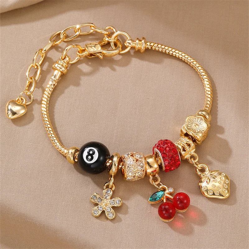 Gold and black beaded bracelet featuring a leopard cross charm and various gemstone beads
