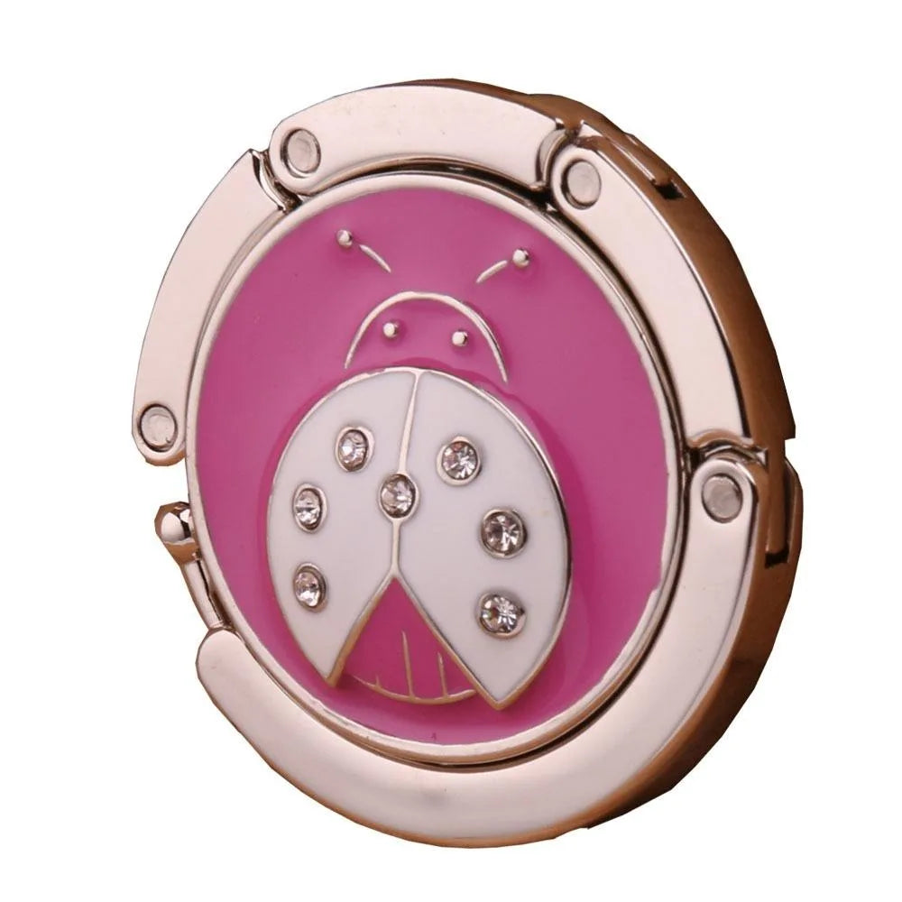 Gancho para mesa con forma de mariposa de oro rosa, diseño rosa y blanco.