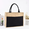 Natürige beige Jute-Sackleinen-Tasche mit schwarzen Henkeln und schwarzem Stofffutter.