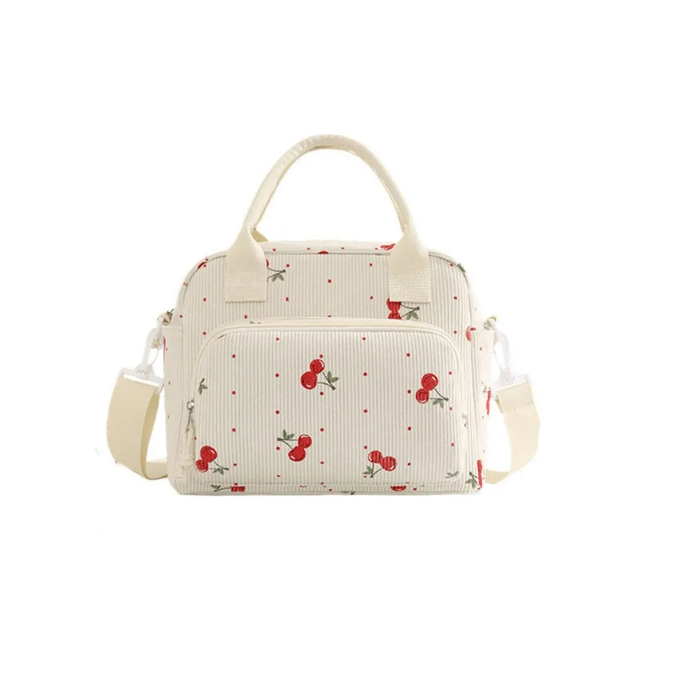 Sac de pique-nique portable en velours côtelé de couleur crème avec un discret motif de fruits rouges.