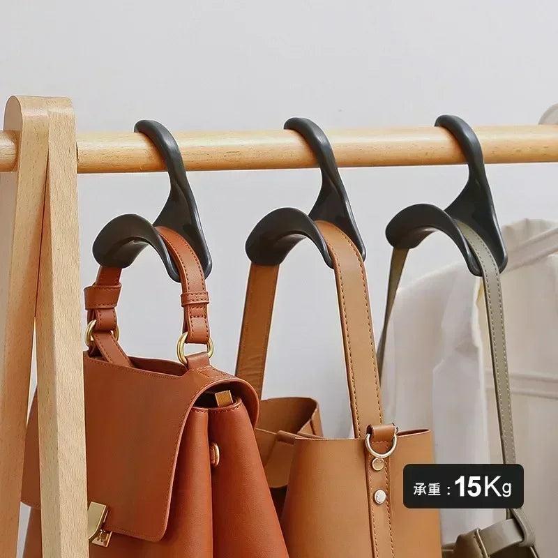 Ein Set aus fünf braunen Lederhaken und -aufhängern auf einem Holzregal.