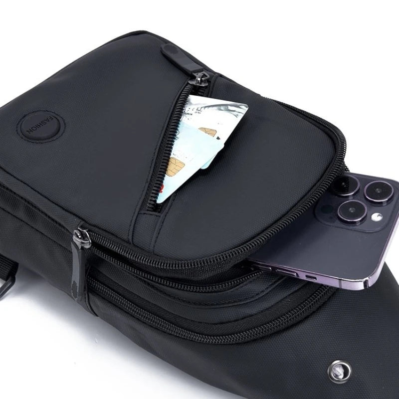 Black men's adjustable crossbody sling bag with a zippered pocket and a smartphone visible.