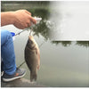 A hand is using a fishing rod to lift a fish from the water.