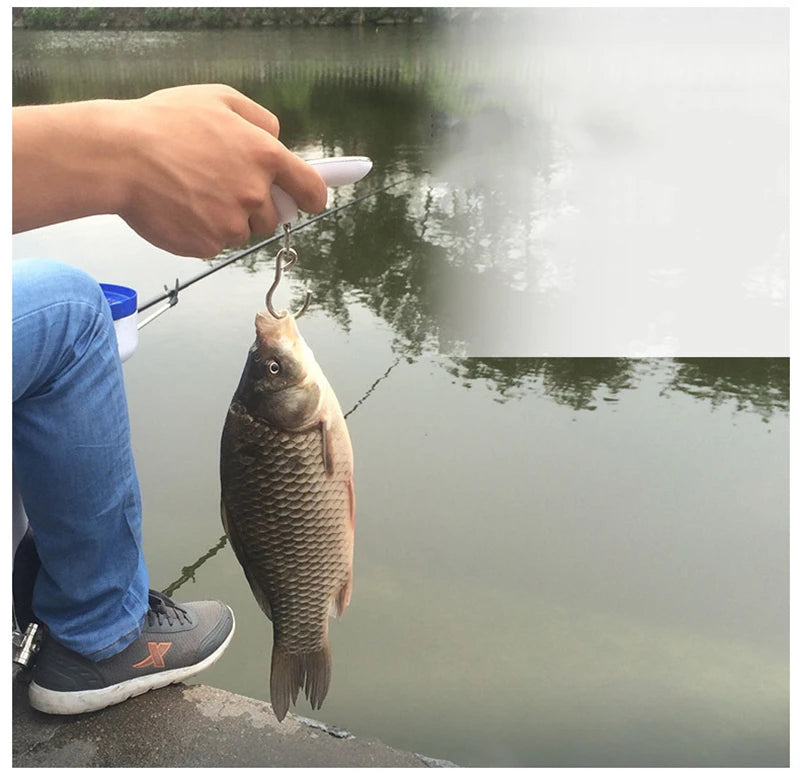 A hand is using a fishing rod to lift a fish from the water.