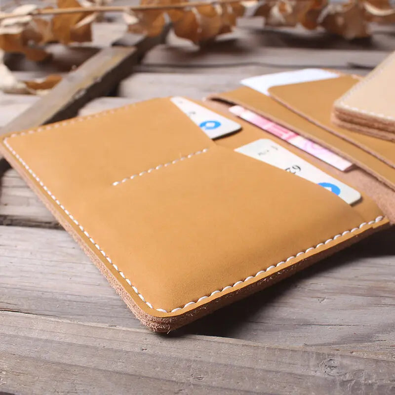 A tan genuine cowhide leather passport and ticket holder with a pink ticket visible on the cover.