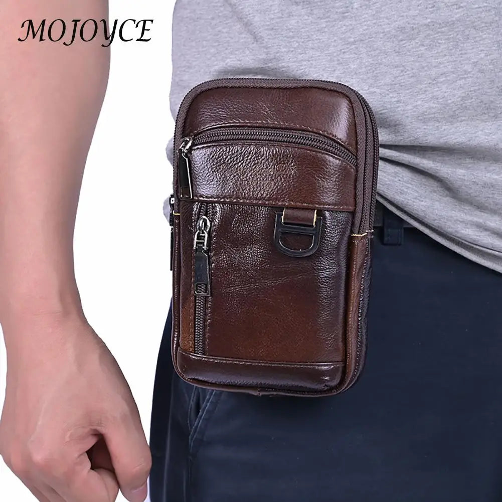 A brown vintage cowhide leather crossbody bag is shown being held by a person against a gray shirt and dark pants.