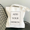 Sac de courses en toile blanche avec une boîte rectangulaire noire à l'avant indiquant 'Add Your Design'.