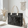 Sac fourre-tout en velours côtelé noir à pois blancs et poignées beige clair, exposé sur une surface en bois blanc.