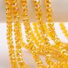Yellow faceted crystal glass beads in a wheel shape strung on a string