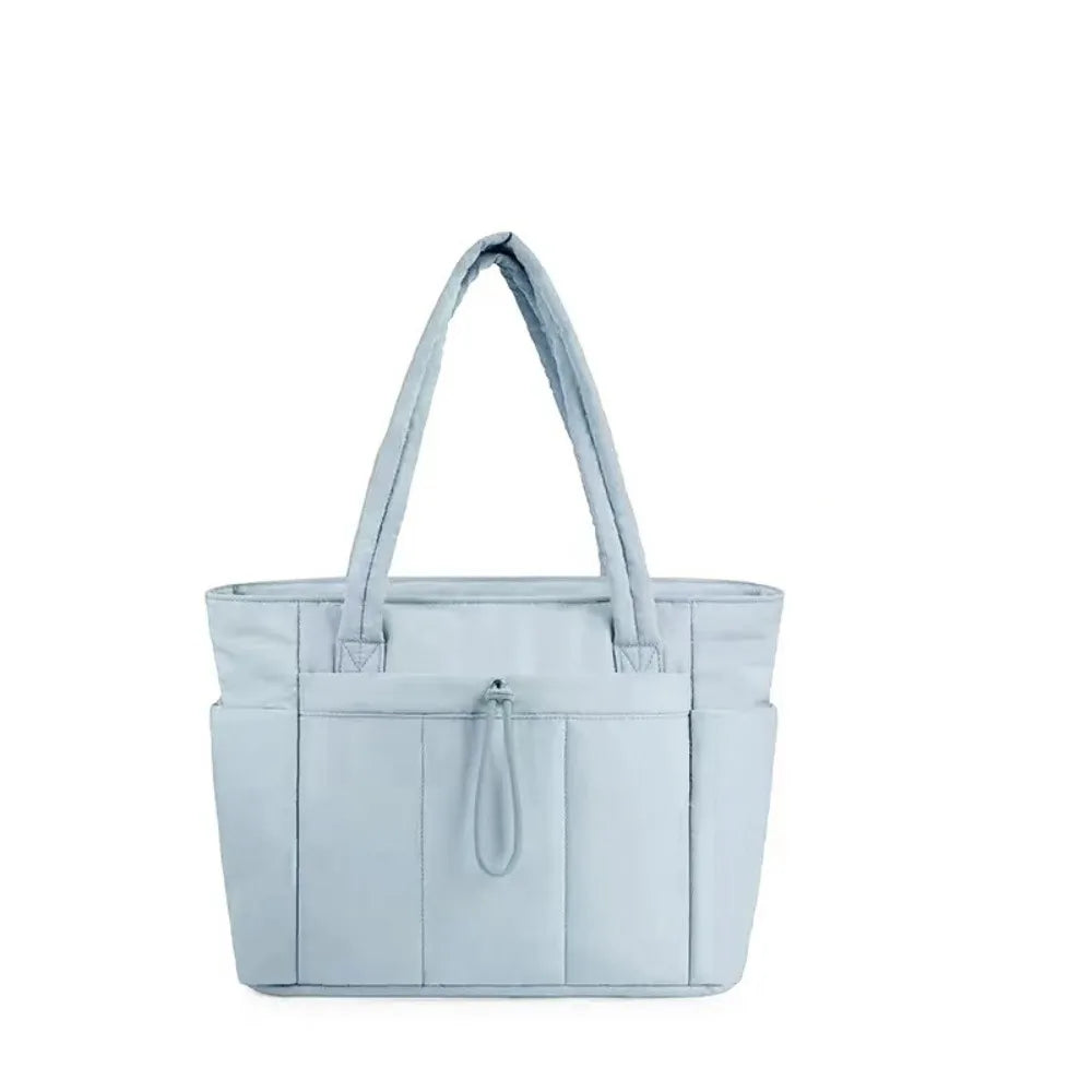 A light blue quilted padded tote bag with a drawstring closure and multiple pockets.