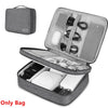 A gray leather cable storage organizer bag with an open lid showing various charging cables and accessories inside.