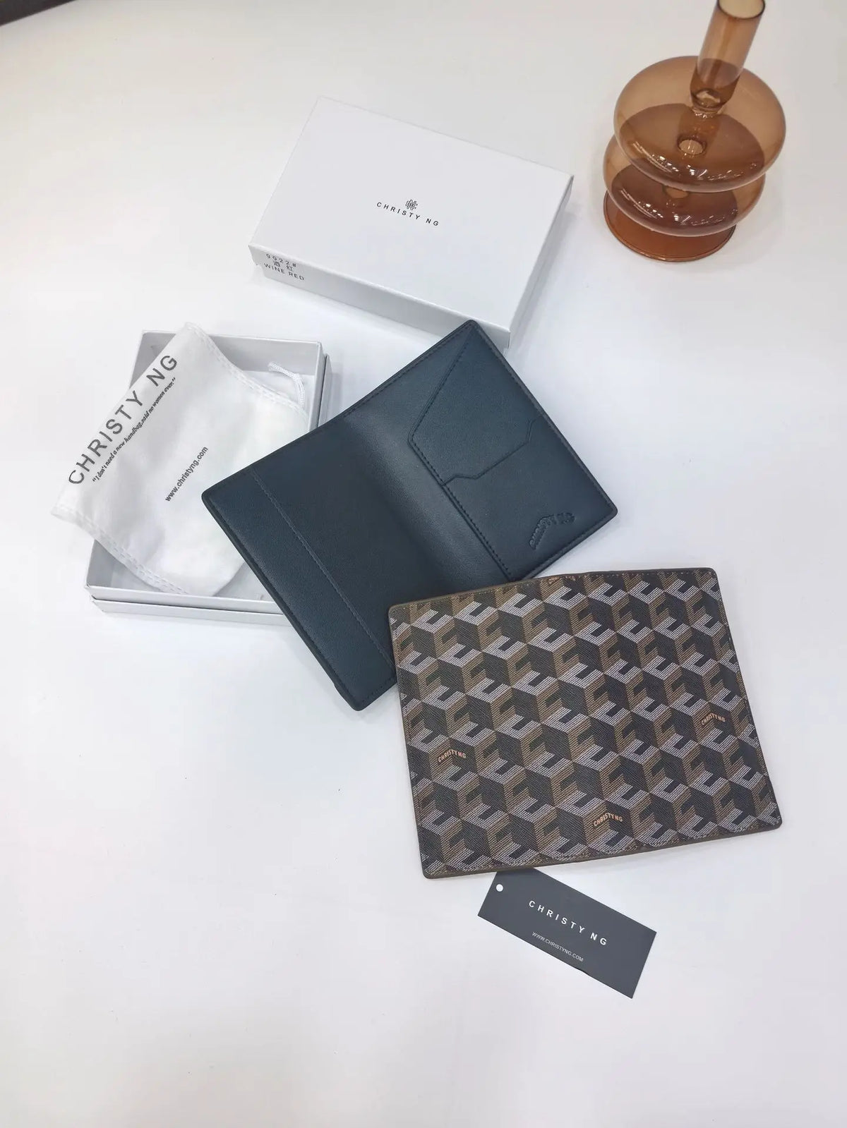 A dark blue geometric print passport wallet next to a white tissue and a minimalist box.