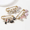 Gold-toned jewelry featuring pearl and floral accents, including a brooch pin design.