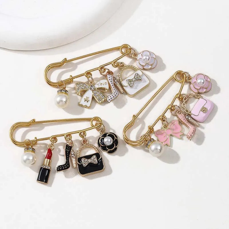 Gold-toned jewelry featuring pearl and floral accents, including a brooch pin design.