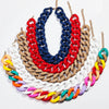 A colorful matte acrylic choker necklace featuring multiple strands of red, blue, white, and gold-toned chains.