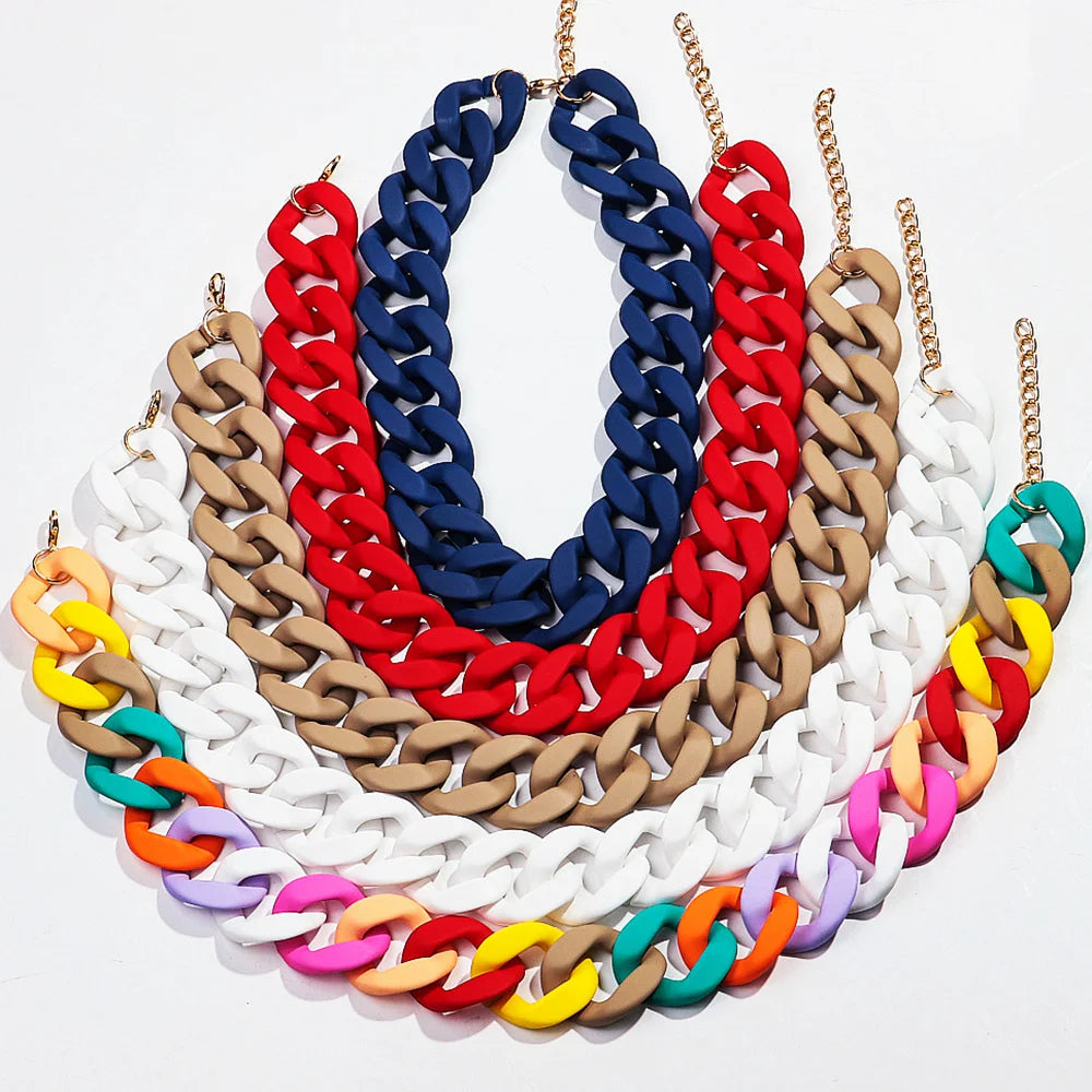 A colorful matte acrylic choker necklace featuring multiple strands of red, blue, white, and gold-toned chains.