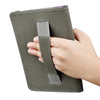 A hand holds a dark olive green universal e-book cover with a protective strap.