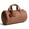 A brown handmade PU leather bag with rose-shaped charms attached to the strap.