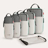 A set of six gray and white expandable compression packing cubes shown in various orientations.