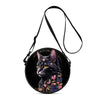 A black cartoon cat round crossbody bag with a black strap and floral accents.
