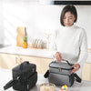 A woman holds a gray insulated thermal lunch bag on a kitchen counter.