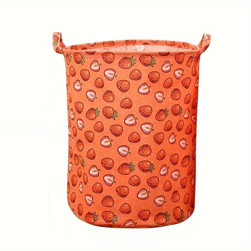 Panier à linge orange avec motif fraises et feuilles vertes.