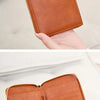 A brown leather passport wallet with a wrist strap and RFID blocking features is shown open.