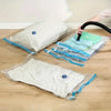 Three reusable vacuum compression storage bags of varying sizes and colors are shown on a wooden floor.