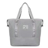 A gray expandable travel organizer bag with two handles shown against a white background.
