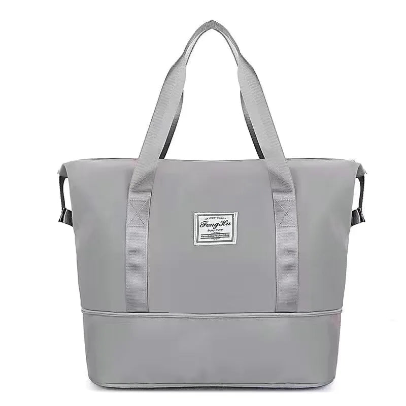 A gray expandable travel organizer bag with two handles shown against a white background.