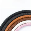 A collection of interchangeable leather bag handles in black, brown, white, and pink with gold metal buckles.