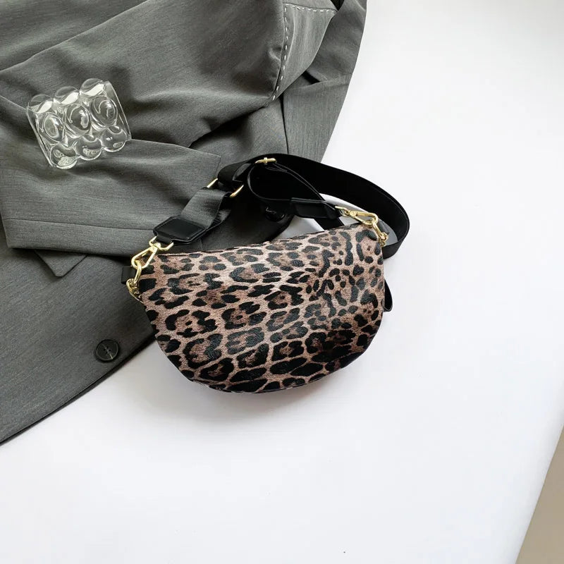 Leopardenmuster-Crossbody-Bauchtasche mit schwarzem Riemen auf einem grauen Blazer.