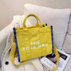 A bright yellow tote bag with blue trim is displayed against a white background.