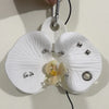 A white realistic phalaenopsis orchid flower shaped keychain with a silver charm.