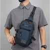 A man wearing a gray shirt holds a dark blue multifunctional chest bag for sports and hiking.