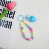 A colorful bead keychain featuring a heart charm and an O-ring clip, with beads in shades of pink, yellow, blue, and green.