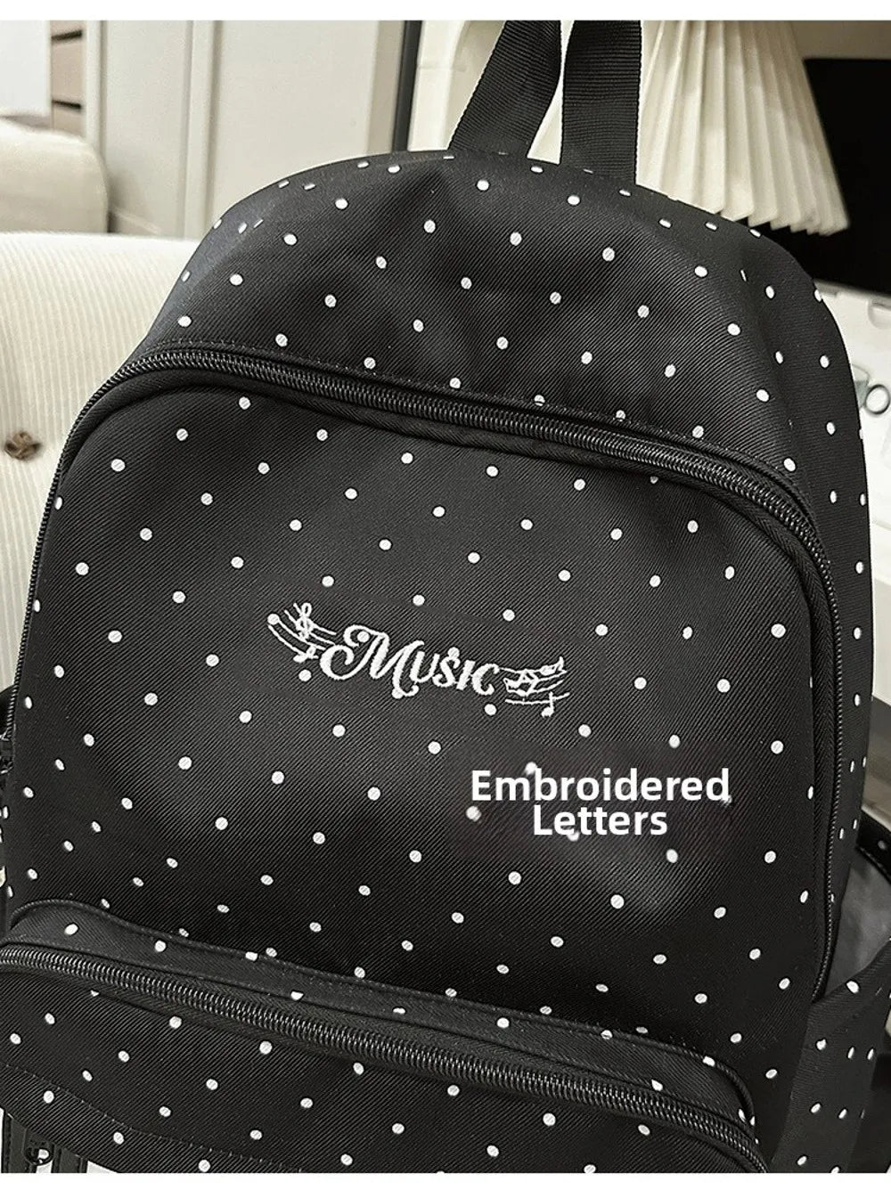 Sac à dos à pois noirs avec lettres brodées sur le devant