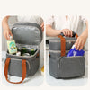 Une personne ouvre un sac de pique-nique isotherme gris à double paroi pour montrer son intérieur et ses fonctionnalités.