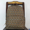 A brown camouflage backpack featuring small animal print patterns, displayed on a wooden hanger.
