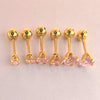 A set of gold-toned stainless steel ear stud earrings featuring pink gemstone accents.
