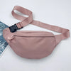 Sac bandoulière en nylon rose clair avec une sangle et un petit nœud en tissu, sur fond blanc.