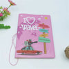 Pink passport cover with a travel theme featuring heart and city labels like New York, London, Paris, and Amsterdam.