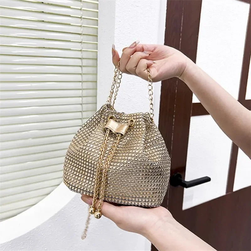 Una mano sostiene un bolso cruz de cordón con pedrería brillante contra un fondo de puerta de madera.