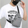 A man wearing a black mask and a white t-shirt holds a gray waterproof crossbody fanny pack.