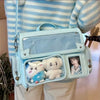 A light blue transparent PU crossbody bag featuring two white plush toys and a small framed photo.