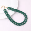 A dark green braided acrylic choker necklace with a gold-colored clasp displayed on a white background.