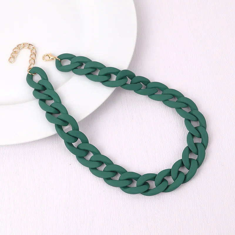 A dark green braided acrylic choker necklace with a gold-colored clasp displayed on a white background.