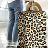 A brown and black leopard print protective luggage cover on a rolling suitcase being held by a person.