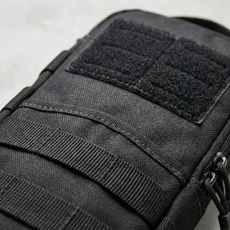Close-up of a black tactical shoulder tool pouch with adjustable straps.