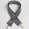 Correa ajustable cruzada de color azul marino oscuro y blanco con estampado paisley y herrajes dorados.